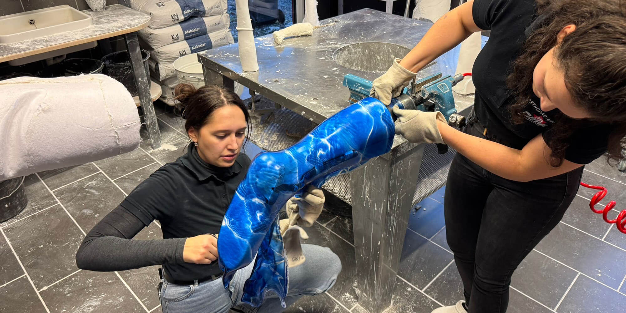 Mitarbeiterinnen bearbeiten eine individuell angepasste Orthese in der Werkstatt