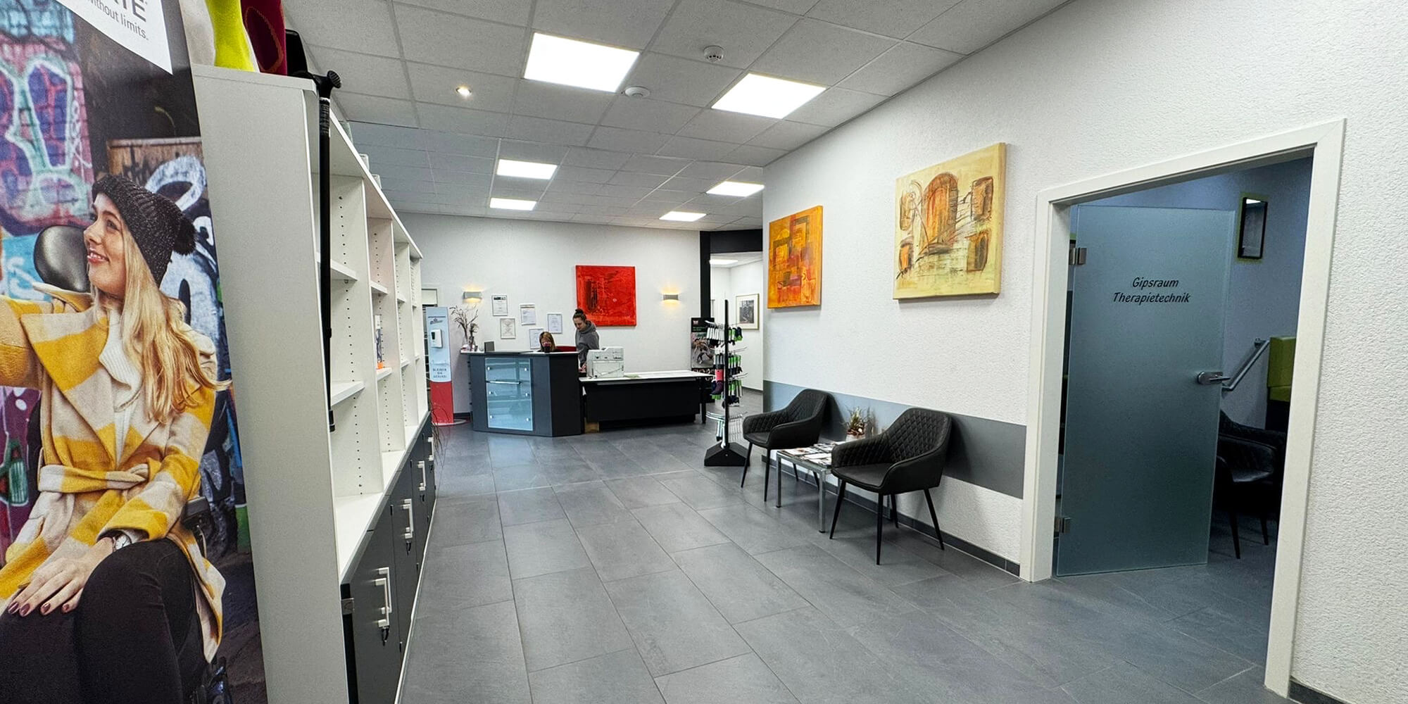Flur im Sanitätshaus mit Empfangstheke, Sitzplätzen und Zugang zu Behandlungsräumen.